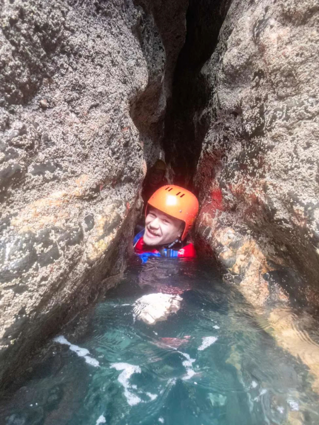 Kernow Coasteering man between boulders